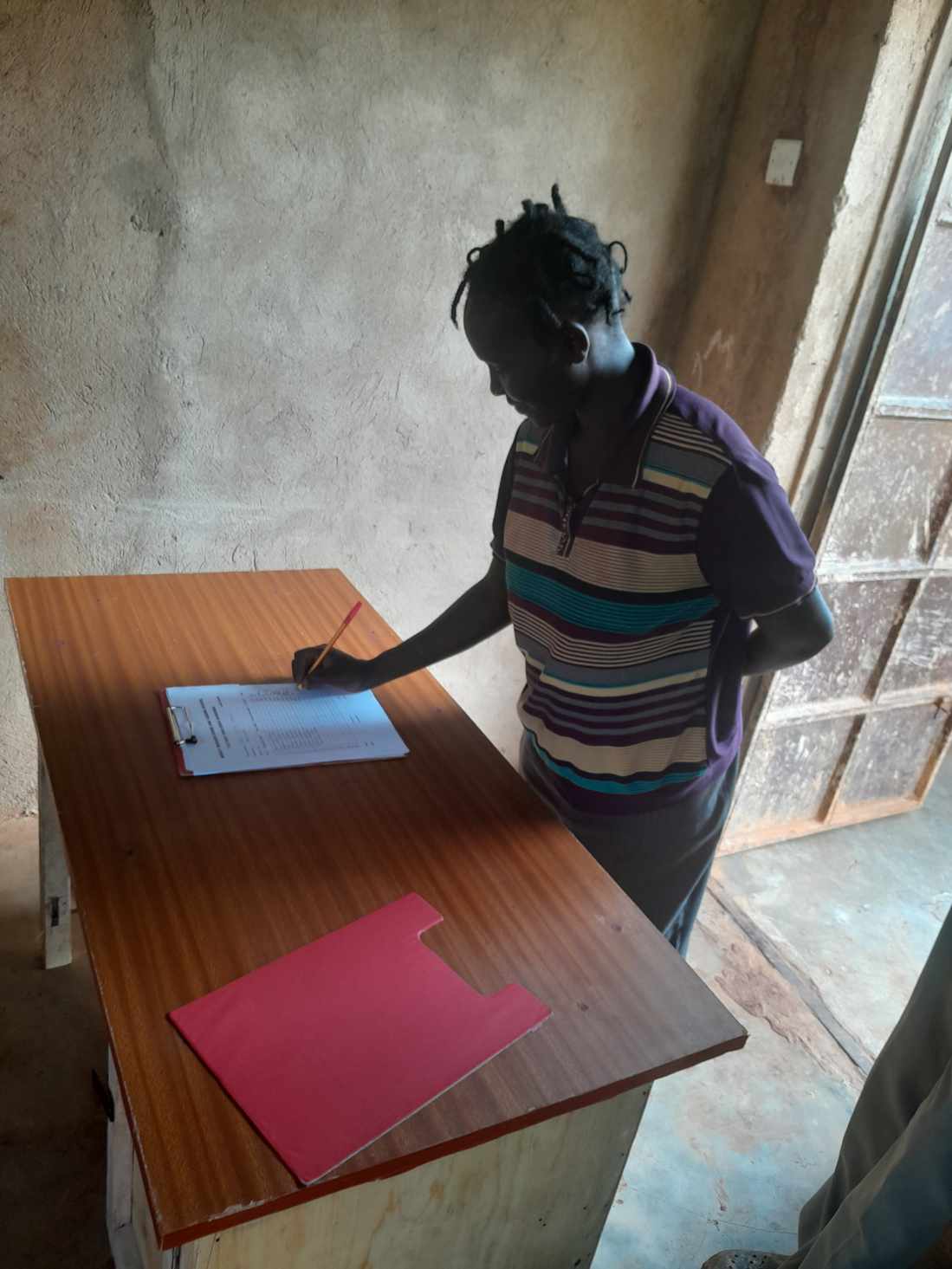 A young volunteer signing in at the mission